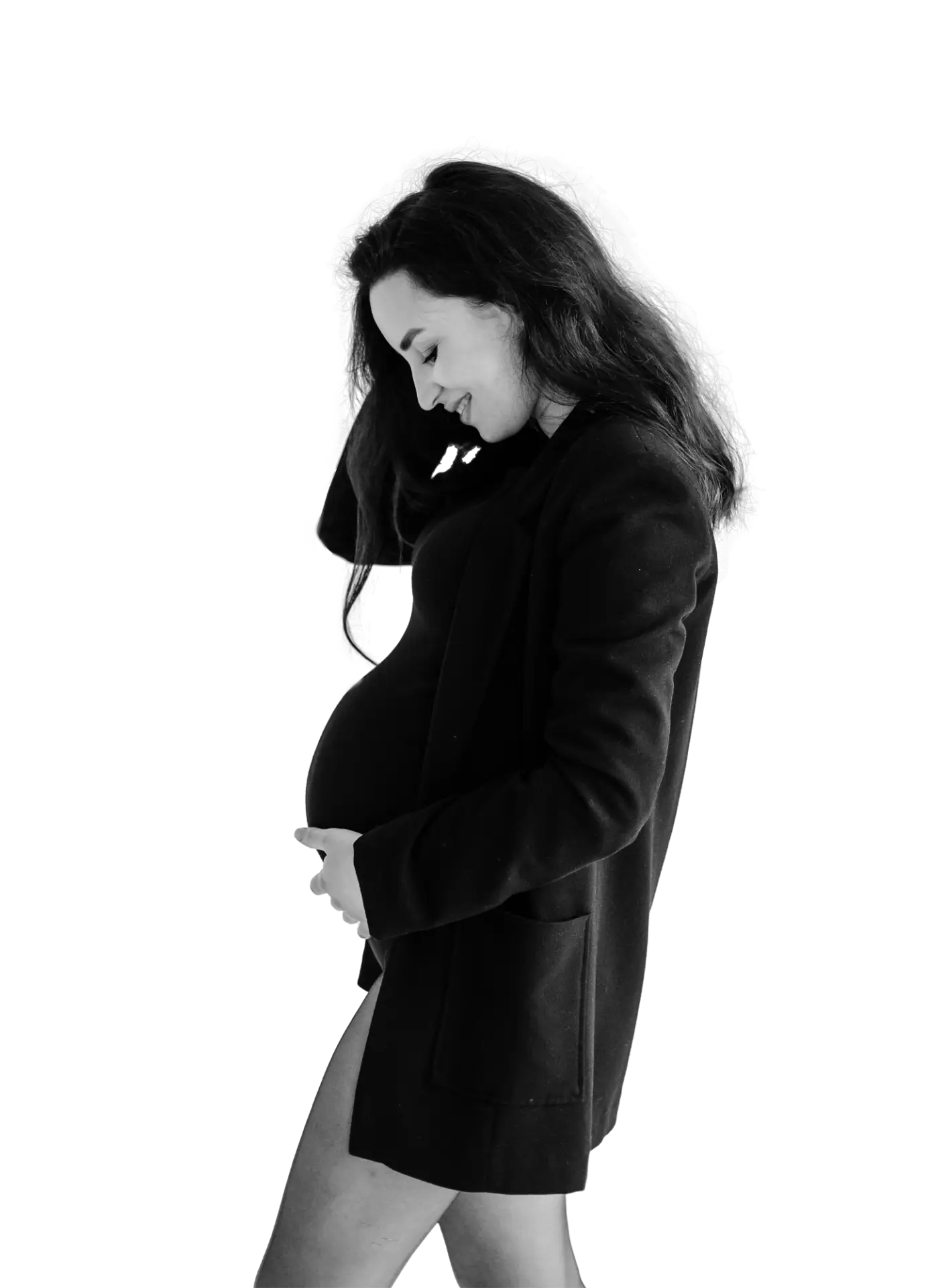 Schwarz-weiß-Bild einer werdenden Mutter, die liebevoll ihren Babybauch umarmt – authentisch und zärtlich eingefangen beim Babybauch Shooting in Dresden im TRU Fotostudio.